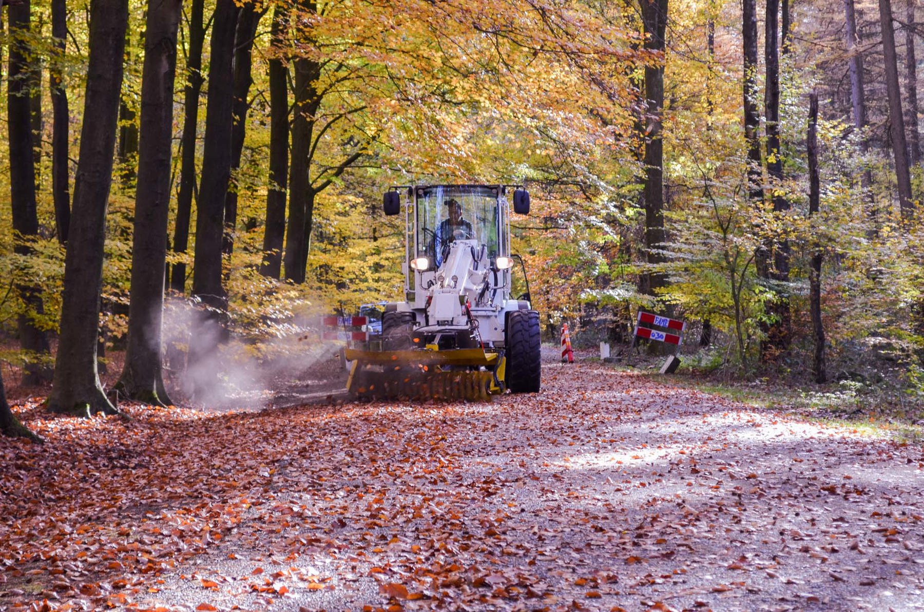 Een afbeelding van een veegmachine op de weg