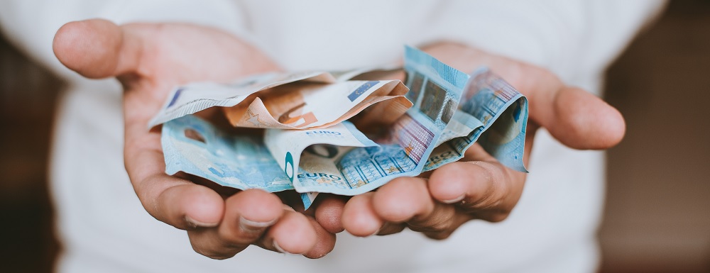 Een afbeelding met geld in een hand
