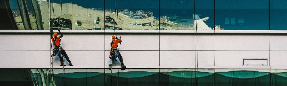 Een afbeelding van glazenwasserd tegen gebouw aan